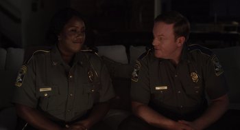 Movie still from “Goodnight Mommy” (2022), directed by Matt Sobel – A couple of people that are sitting on a couch; Medium shot, Over the shoulder angle