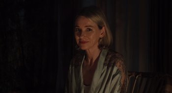 Movie still from “Goodnight Mommy” (2022), directed by Matt Sobel – A woman with blonde hair sitting in front of a curtain; Close Up shot, Over the shoulder angle