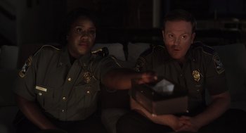 Movie still from “Goodnight Mommy” (2022), directed by Matt Sobel – A couple of people sitting on top of a couch; Medium shot, Over the shoulder angle