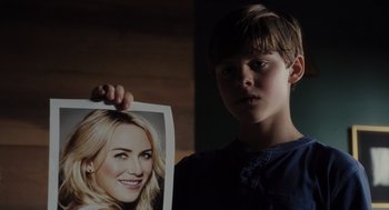 Movie still from “Goodnight Mommy” (2022), directed by Matt Sobel – A young boy holding up a picture of a woman; Close Up shot, Over the shoulder angle