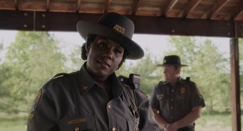 Movie still from “Goodnight Mommy” (2022), directed by Matt Sobel – A woman in a uniform and a man in a hat; Close Up shot, Over the shoulder angle