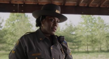 Movie still from “Goodnight Mommy” (2022), directed by Matt Sobel – A woman wearing a hat and a uniform; Close Up shot, Over the shoulder angle