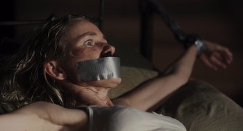 Movie still from “Goodnight Mommy” (2022), directed by Matt Sobel – A woman with duct tape around her mouth; Close Up shot, High angle