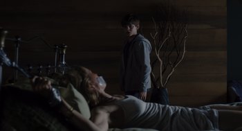 Movie still from “Goodnight Mommy” (2022), directed by Matt Sobel – A man and a woman laying in a bed next to each other; Medium shot, Over the shoulder angle