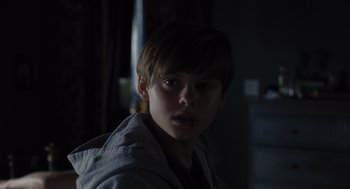 Movie still from “Goodnight Mommy” (2022), directed by Matt Sobel – A young man is looking into the camera; Close Up shot, Over the shoulder angle