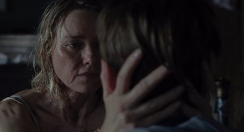 Movie still from “Goodnight Mommy” (2022), directed by Matt Sobel – A person holding a hand near a woman's face; Close Up shot, Over the shoulder angle