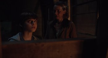 Movie still from “Goodnight Mommy” (2022), directed by Matt Sobel – A woman and a boy are looking at something; Medium shot, Over the shoulder angle