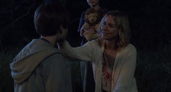 Movie still from “Goodnight Mommy” (2022), directed by Matt Sobel – A woman holding a teddy bear and a boy; Medium shot, Over the shoulder angle