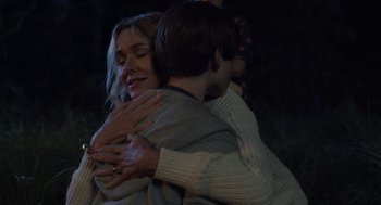 Movie still from “Goodnight Mommy” (2022), directed by Matt Sobel – Two people hugging each other in the dark; Medium shot, Over the shoulder angle