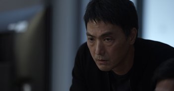 Movie still from “Gran Turismo” (2023), directed by Neill Blomkamp – A person sitting in front of a window; Close Up shot, Low angle