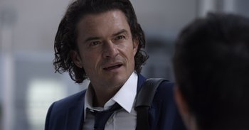 Movie still from “Gran Turismo” (2023), directed by Neill Blomkamp – A person wearing a suit and tie; Close Up shot, Over the shoulder angle