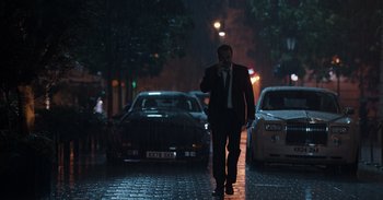 Movie still from “Gran Turismo” (2023), directed by Neill Blomkamp – A man in a suit walking down a street at night; Wide shot, Low angle