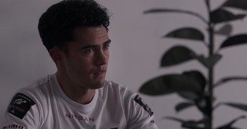 Movie still from “Gran Turismo” (2023), directed by Neill Blomkamp – A person wearing a white shirt; Close Up shot, Over the shoulder angle