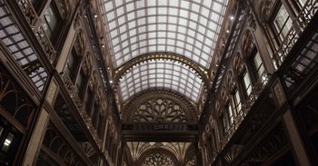 Movie still from “Gran Turismo” (2023), directed by Neill Blomkamp – The ceiling of the building has a glass roof; Extreme Wide shot, High angle