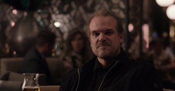 Movie still from “Gran Turismo” (2023), directed by Neill Blomkamp – A person sitting in a room; Close Up shot, Over the shoulder angle