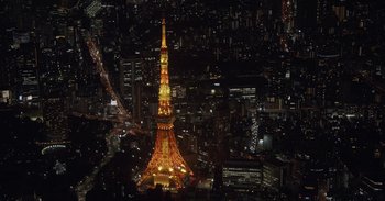 Movie still from “Gran Turismo” (2023), directed by Neill Blomkamp – A view of the eiffel tower at night from above; Extreme Wide shot, High angle