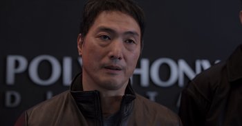 Movie still from “Gran Turismo” (2023), directed by Neill Blomkamp – A person wearing a leather jacket; Close Up shot, Over the shoulder angle