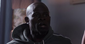 Movie still from “Gran Turismo” (2023), directed by Neill Blomkamp – A person wearing a hooded sweatshirt; Close Up shot, Low angle