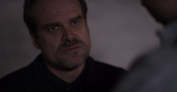 Movie still from “Gran Turismo” (2023), directed by Neill Blomkamp – A person wearing a black shirt; Close Up shot, Over the shoulder angle