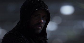 Movie still from “Gran Turismo” (2023), directed by Neill Blomkamp – A person wearing a hooded jacket; Close Up shot, Low angle