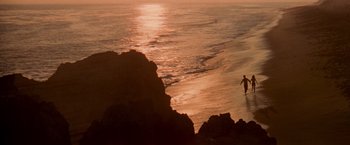 Movie still from “Grease” (1978), directed by Randal Kleiser – A person standing on a beach near the ocean; Extreme Wide shot, High angle