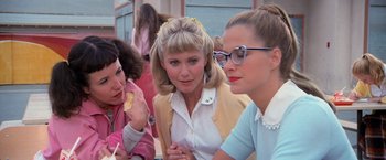 Movie still from “Grease” (1978), directed by Randal Kleiser – A group of women sitting next to each other; Medium shot, Low angle