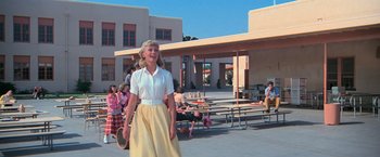 Movie still from “Grease” (1978), directed by Randal Kleiser – A woman standing in front of a group of people; Wide shot, Low angle