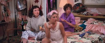 Movie still from “Grease” (1978), directed by Randal Kleiser – A group of women sitting on the floor eating food; Medium shot, High angle