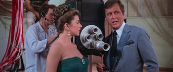 Movie still from “Grease” (1978), directed by Randal Kleiser – A man and a woman in front of a video camera; Close Up shot, Over the shoulder angle