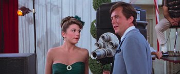 Movie still from “Grease” (1978), directed by Randal Kleiser – A man and a woman in front of a video camera; Close Up shot, Over the shoulder angle