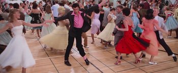 Movie still from “Grease” (1978), directed by Randal Kleiser – A group of people dancing on a dance floor; Wide shot, High angle