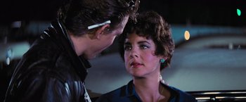 Movie still from “Grease” (1978), directed by Randal Kleiser – A man and a woman looking at one another; Close Up shot, Over the shoulder angle