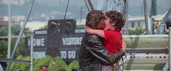 Movie still from “Grease” (1978), directed by Randal Kleiser – A man and a woman kissing on a swing; Medium shot, Low angle