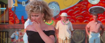 Movie still from “Grease” (1978), directed by Randal Kleiser – A man and a woman are standing in front of each other; Close Up shot, Over the shoulder angle