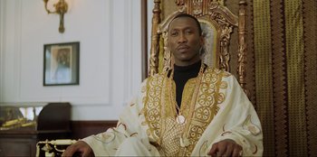 Movie still from “Green Book” (2018), directed by Peter Farrelly – A man sitting in a chair wearing a robe; Medium shot, Low angle