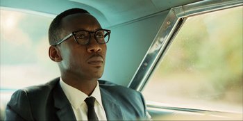 Movie still from “Green Book” (2018), directed by Peter Farrelly – A man in a suit and tie sitting in a car; Close Up shot, Low angle