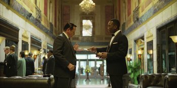 Movie still from “Green Book” (2018), directed by Peter Farrelly – Two men in suits are talking in a lobby; Medium shot, Over the shoulder angle