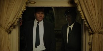 Movie still from “Green Book” (2018), directed by Peter Farrelly – A man in a suit and tie standing next to another man in a suit and tie; Medium shot, Low angle