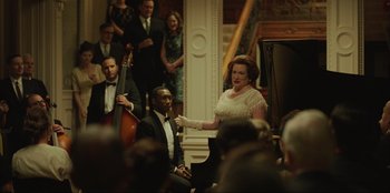 Movie still from “Green Book” (2018), directed by Peter Farrelly – A woman in a white dress is singing at a concert; Medium shot, Over the shoulder angle
