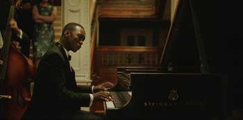 Movie still from “Green Book” (2018), directed by Peter Farrelly – A man in a suit playing a piano; Medium shot, Low angle