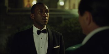 Movie still from “Green Book” (2018), directed by Peter Farrelly – A man wearing a tuxedo and a bow tie; Close Up shot, Over the shoulder angle
