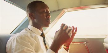 Movie still from “Green Book” (2018), directed by Peter Farrelly – A man in a white shirt and a yellow and white striped tie; Close Up shot, Low angle