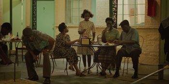 Movie still from “Green Book” (2018), directed by Peter Farrelly – A group of people sitting around a table; Wide shot, High angle