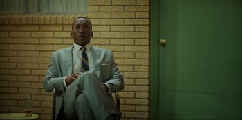 Movie still from “Green Book” (2018), directed by Peter Farrelly – A man sitting in a chair in front of a brick wall; Medium shot, Low angle