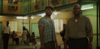 Movie still from “Green Book” (2018), directed by Peter Farrelly – A man standing next to another man in a building; Medium shot, Over the shoulder angle