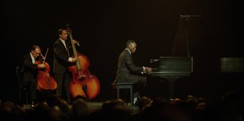 Movie still from “Green Book” (2018), directed by Peter Farrelly – A man playing a piano while a man plays a double bass; Wide shot, High angle