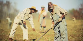 Movie still from “Green Book” (2018), directed by Peter Farrelly – A group of men working in a field; Wide shot, High angle