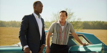 Movie still from “Green Book” (2018), directed by Peter Farrelly – Two men standing next to each other in front of a car; Medium shot, Low angle