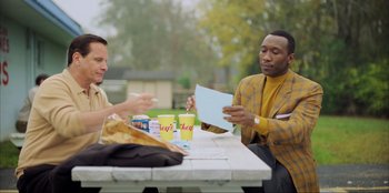 Movie still from “Green Book” (2018), directed by Peter Farrelly – Two men are sitting at a table and one of them is holding a piece of paper; Medium shot, Over the shoulder angle