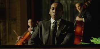 Movie still from “Green Book” (2018), directed by Peter Farrelly – A man in a suit and tie sitting in front of an instrument; Close Up shot, Low angle